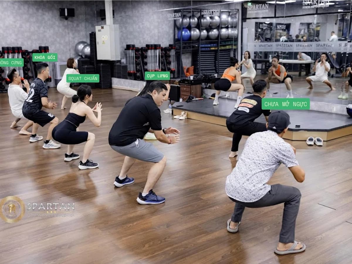 Nhóm hội viên Spartan tập squat theo nhịp cùng huấn luyện viên